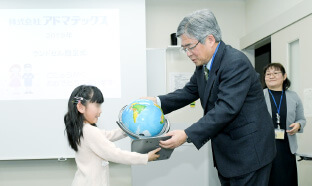 就学祝いの地球儀を手渡す様子